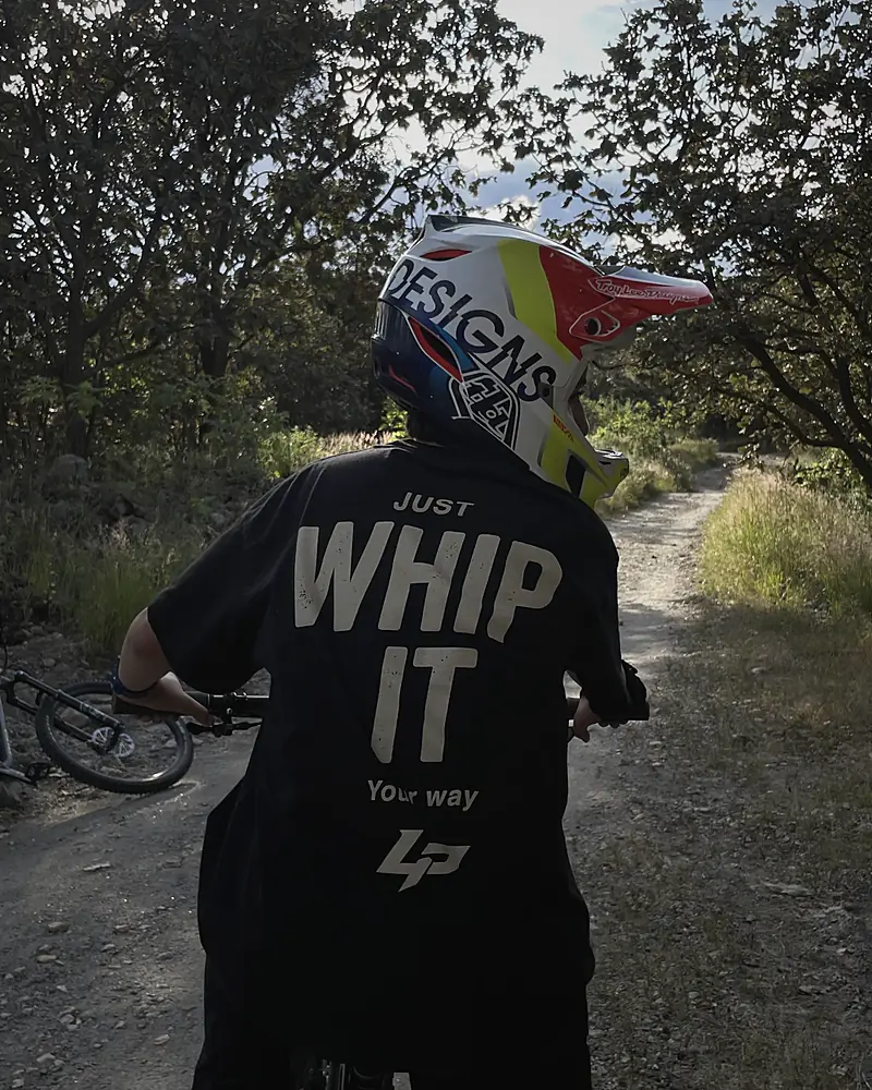 Rider de espaldas con la Whip It negra en el sendero